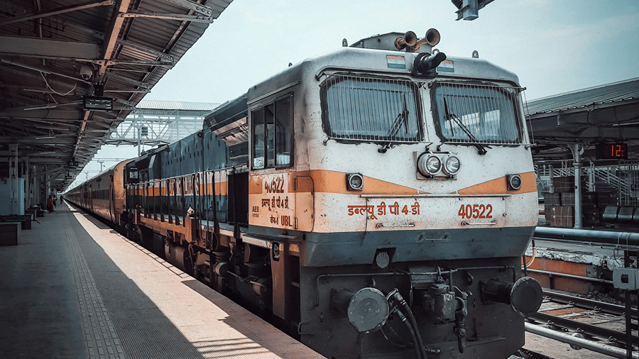 A front view of an electric train stationed under a covered platform.