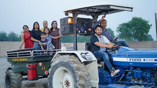 Group of eople enjoying a tractor ride surrounded by trees at Themis Mudhouse - A Nature's Retreat Resort & Wellness