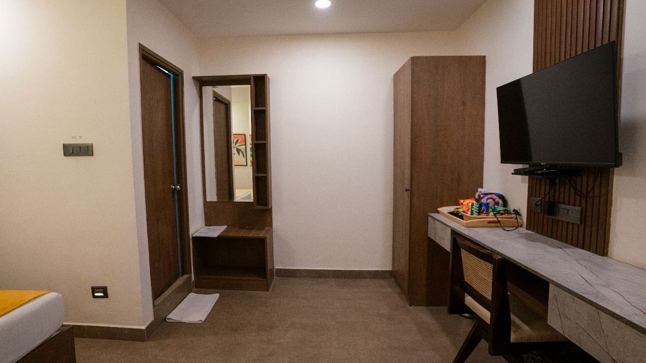 A spacious room with a wide-angle view, showing the work desk, TV, and ample storage cabinets at Hotel Kyzen Smartstays – Smart, Reliable, Kyzen