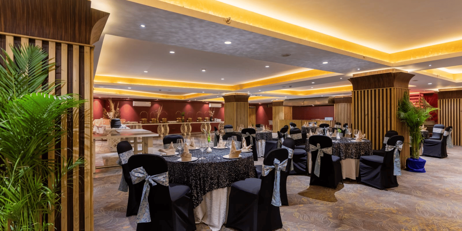 Galaxy Banquet Hall at Papaya Tree Hotels set up with round dining tables and elegant decor for formal dinners and celebrations.
