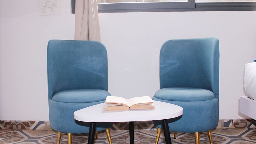 Chairs placed alongside each other in front of a table of a Deluxe Cottage Room at Royale Amata - By the Beach.
