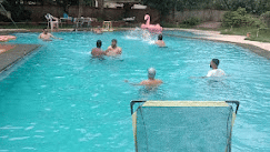 Swimming pool view at Fantasy Golf Resort, Bangalore with guests relaxing in a serene setting.