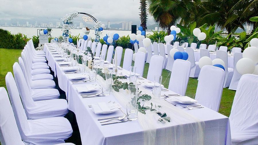 A long table with white chairs on a green lawn near the bay - Alibu Resort Nha Trang