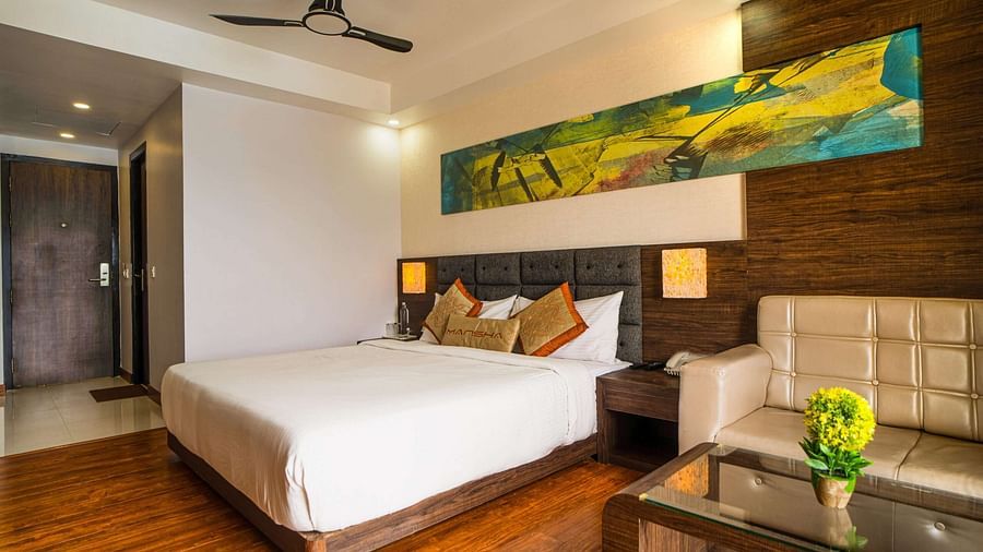 A room with a bed, a sofa, and a coffee table at Mansha Hotel Regency.