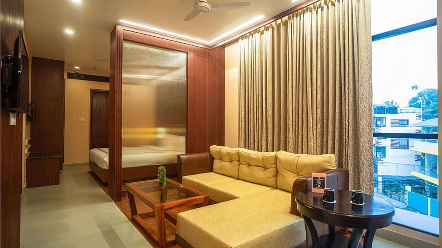 A modern suite at Mansha Palace features a comfortable sofa, a coffee table, and a separate sleeping area.