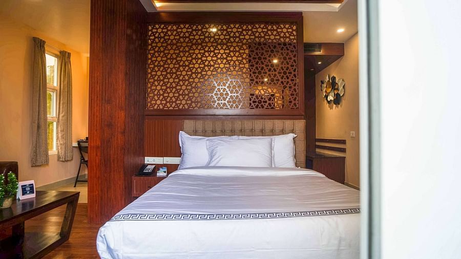 A comfortable and stylish bedroom at Mansha Palace features warm lighting and wooden accents.