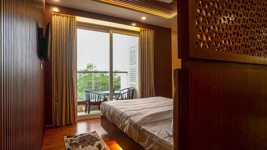 A stylish bedroom at Mansha Palace features a comfortable bed and a balcony with outdoor seating.