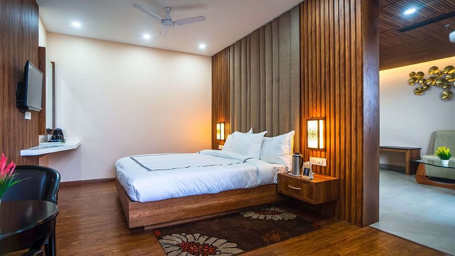 A comfortable bedroom at Mansha Palace opens into a separate living area with a sofa and wall art.