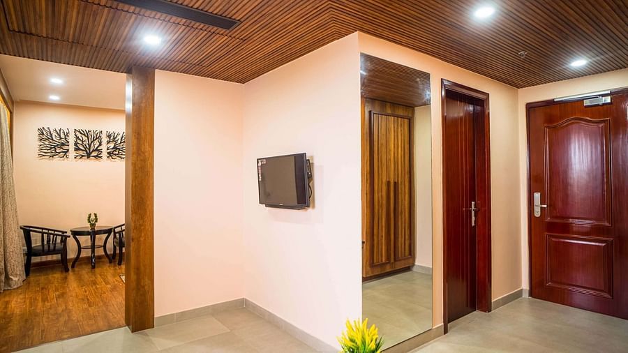 A hotel room at Mansha Palace offers a view into a seating area and includes a wardrobe with a mirror.