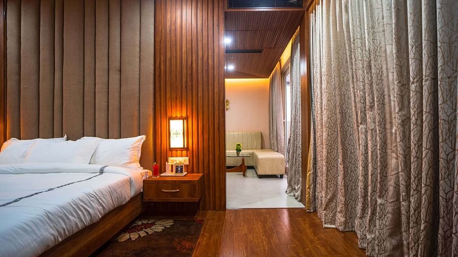 A comfortable bedroom at Mansha Palace opens into a separate seating area with a sofa and ottoman.