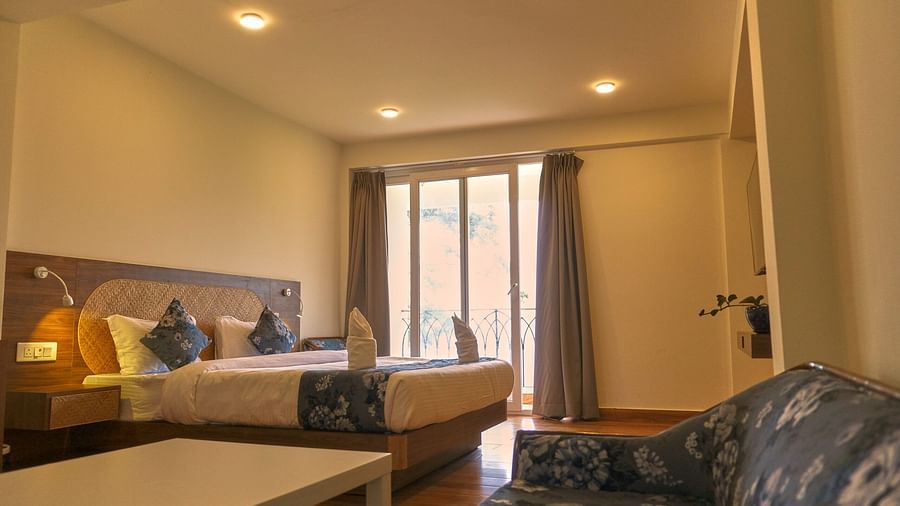 A well-furnished bedroom with a double bed and a seating area. - VITS Kunjham Retreat, Gangtok