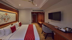 a king size bed facing the workstation and TV - Golden Tulip, Tirupati