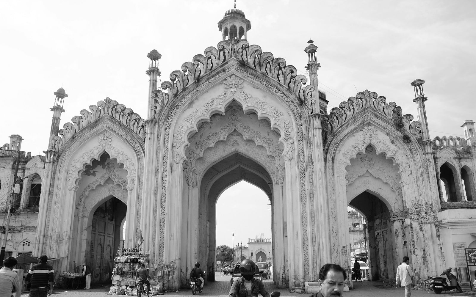 An overview of chota imambara with archways and people in front of it in view.