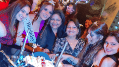 Group of friends celebrating a birthday with a themed cake at Central Courtyard Boutique Hotel.