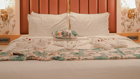 Bedroom with upholstered headboard and wall panels at Hotel Mumbai House, Digha, Airoli.