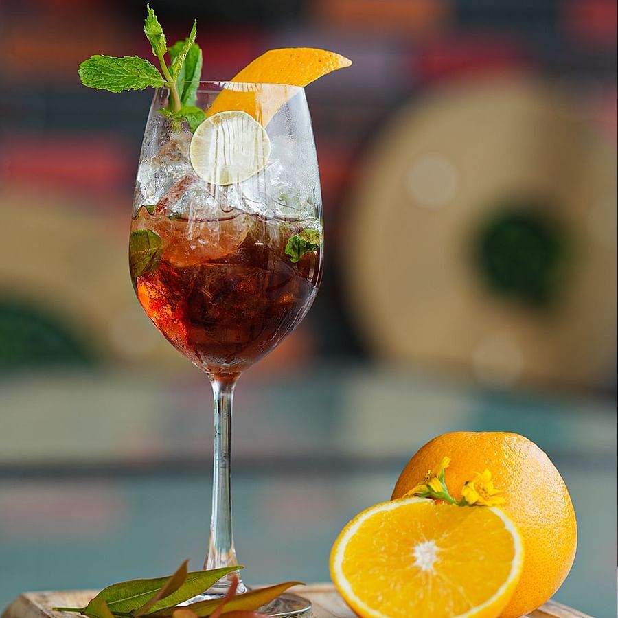 alt-text Refreshing Cocktail with Orange Slices and Mint Leaves