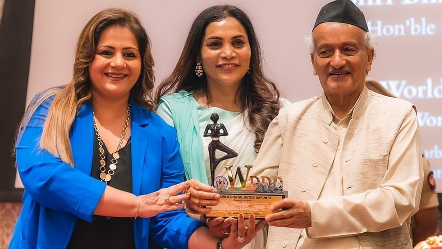 Kiran Bawa receiving an award by a woman and a man - IOSIS Spa & Wellness