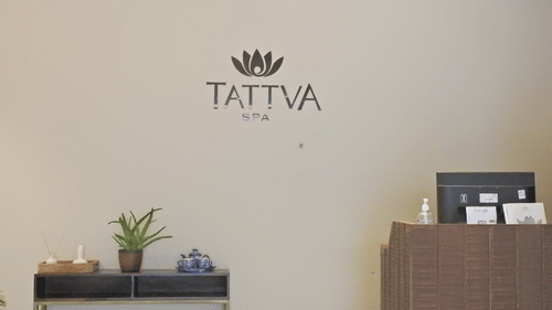 The signage of tattva spa on the wall with the reception desk below at  Polo Hotel Agartala
