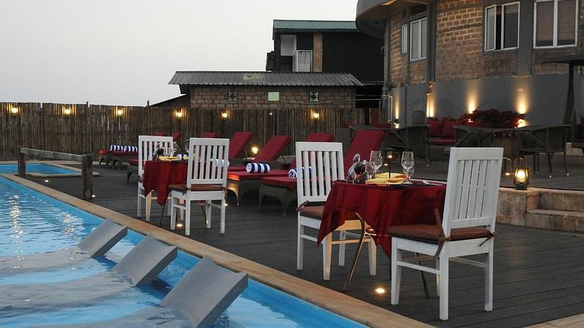tables and chairs kept for couple beside Infinity pool at Cherrapunji 