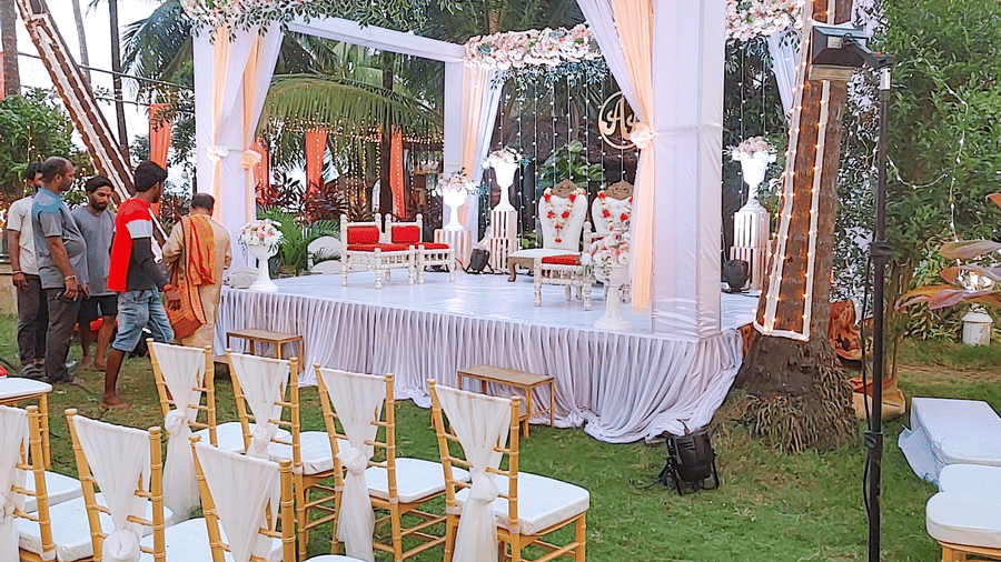 Wedding mandap with white drapes, floral canopy, and chairs at Paradise Lagoon Resort, Udupi.