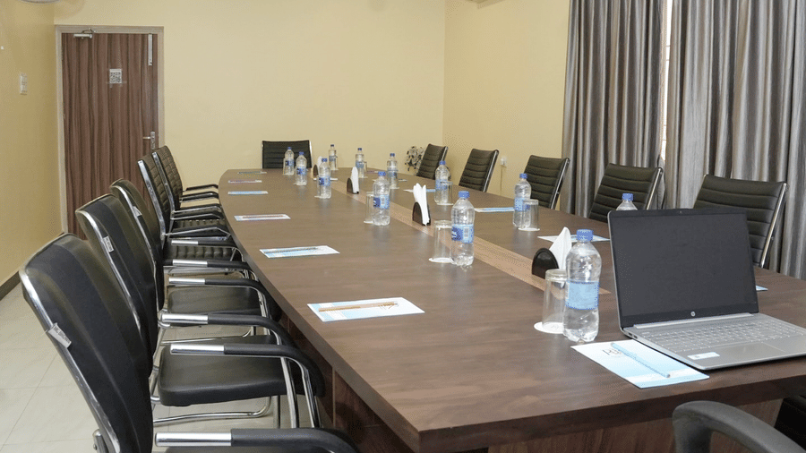 An angled shot of a well-equipped meeting room with high-back chairs and a laptop at the Ram Bhawan Ram Yamuna Prasad Hotel and Resort.