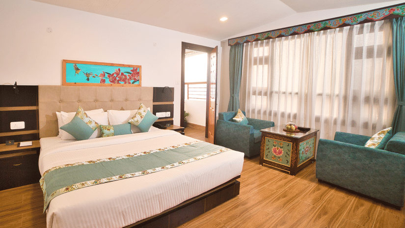 Well-appointed room at Voyage Glenz Resort with a queen bed, seating area, and modern decor.