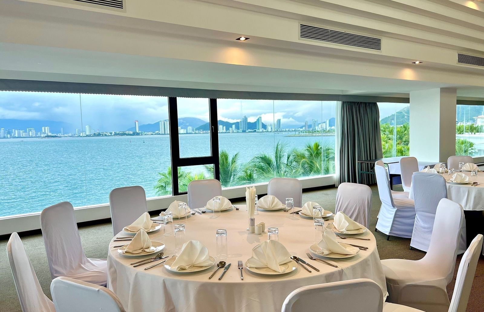 A high angle shot of our Panorama meeting hall with round tables and comfortable chairs - Alibu Resort