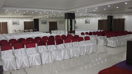 Jyothi hall with seats arranged and lights on the ceiling at Hotel Green Apple