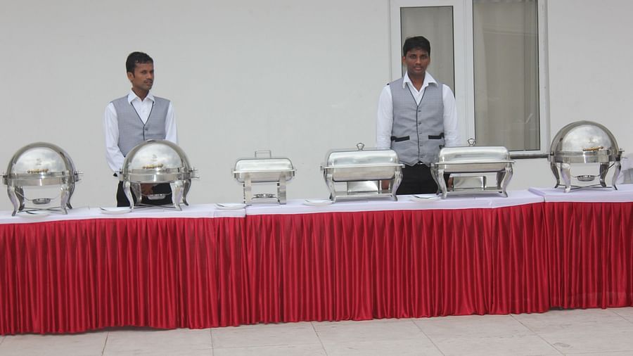 Two man standing behind a bufffet table at Swathi Hall at Hotel Green Apple