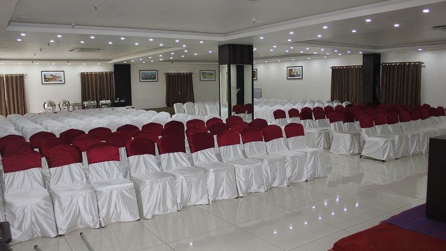 Jyothi hall with seats arranged and lights on the ceiling at Hotel Green Apple