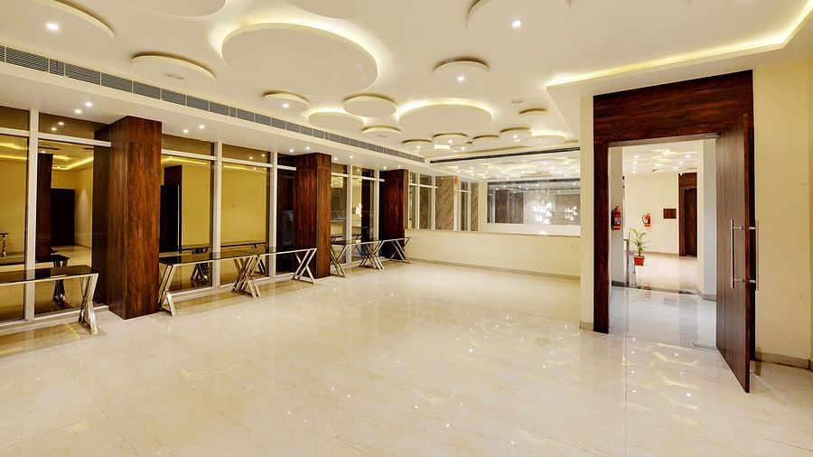 Contemporary banquet hall with circular recessed ceiling lights and stainless steel buffet tables.