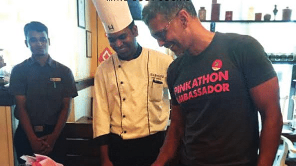 Milind Soman with a chef cutting a cake at Hablis Hotel, Chennai