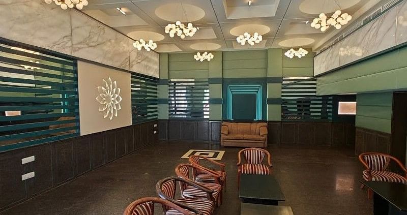 Full view shot of the Boardroom at Hotel Gold, Panipat with several brown coloured leather arm chairs arranged facing towards each other.