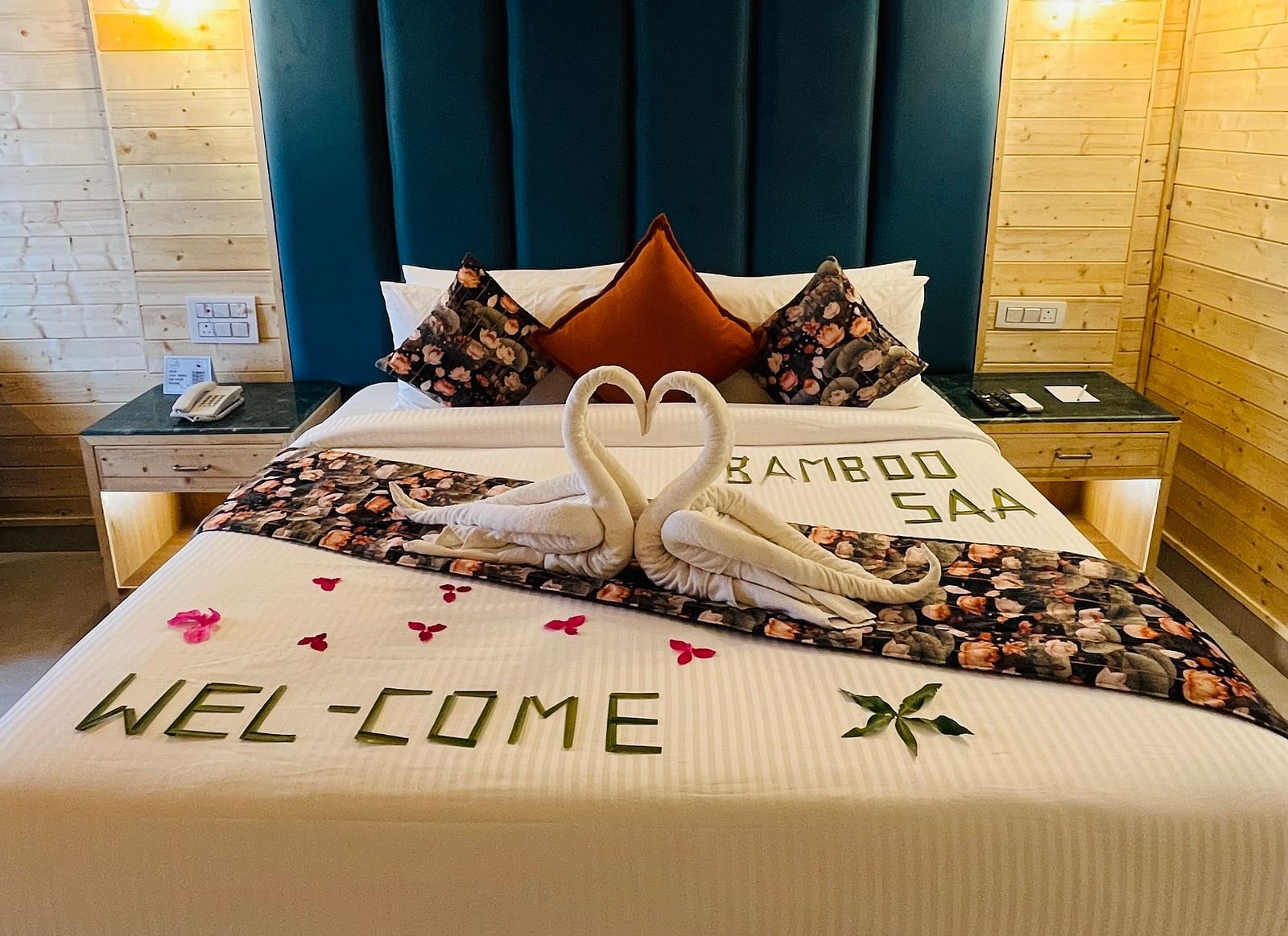 An interior shot of a hotel room with a neatly made bed and decorative swans are folded from towels and placed on the bed - Bamboo Saa Mulberry Resort, Pushkar