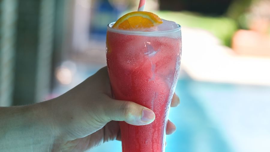A person holding a glass of Pomegranate Cooler | Mango Hill, Pondicherry