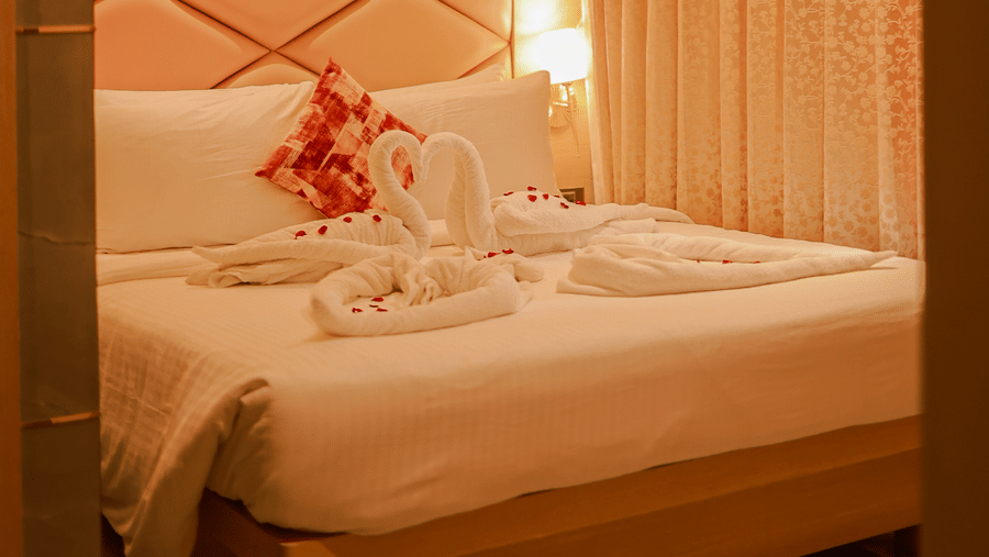 Bedroom with upholstered headboard and warm lighting at Hotel Mumbai House Digha, Airoli.