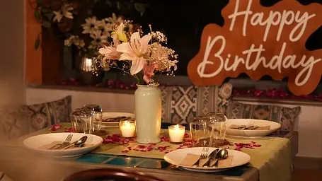 Table setup for a birthday celebration with flowers and lights at Karma Chalets.