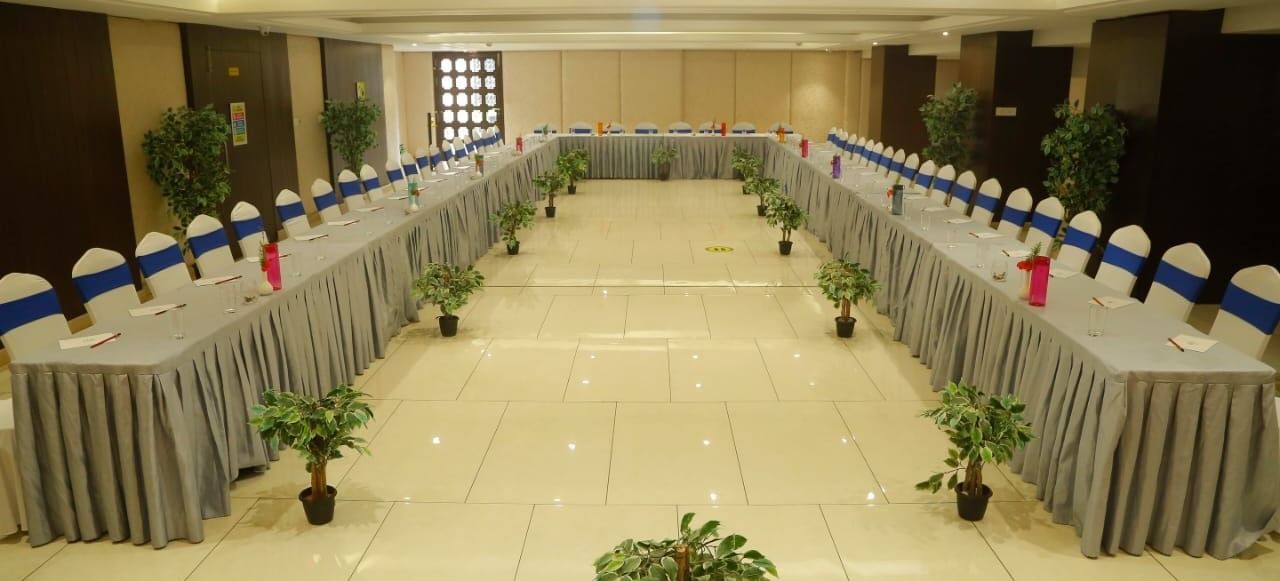 Spacious banquet hall with chairs arranged around the table at The Hamuse Hotel, Kodaikanal.