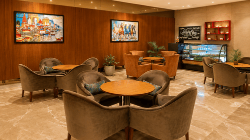 A lobby area with cushions, tables, and wall arts.