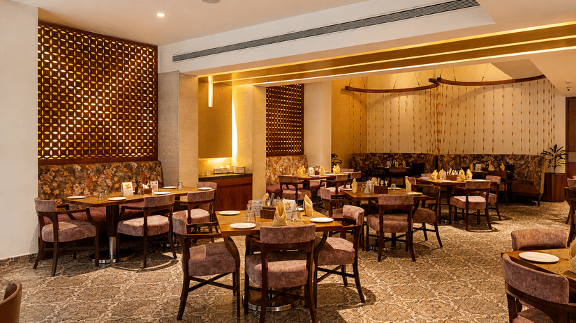Indoor dining area at Pride Premier Pune with tables, chairs and contemporary décor.