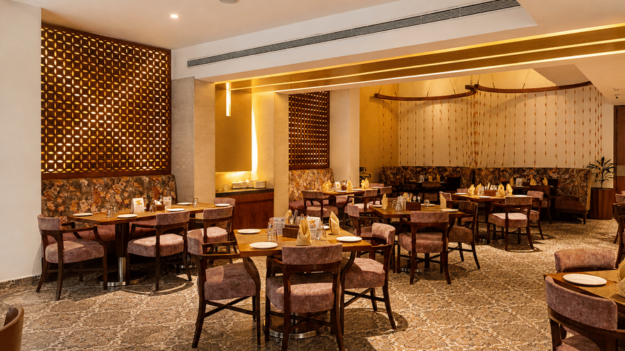 Indoor dining area at Pride Premier Pune with tables, chairs and contemporary décor.