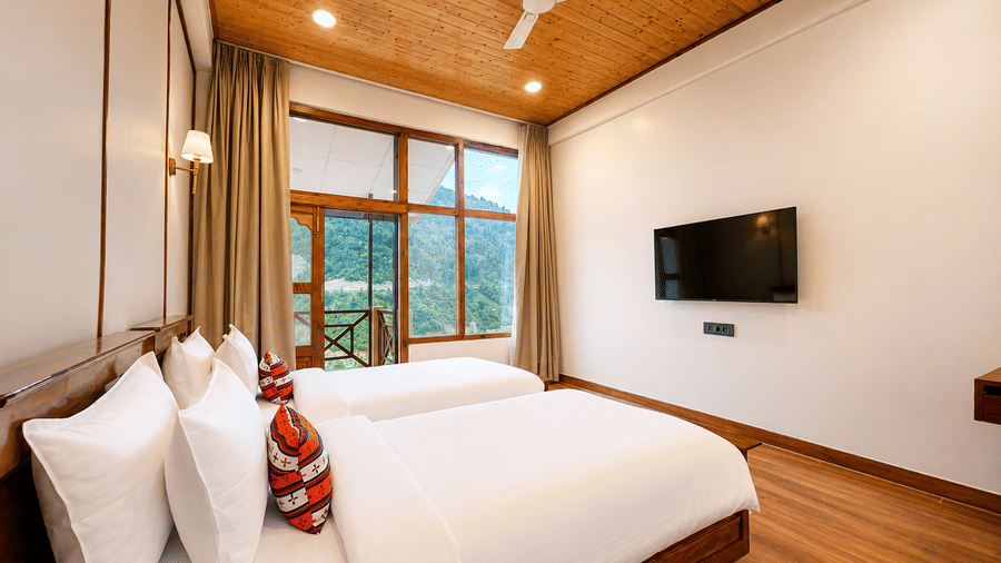 Room with twin beds, white pillows, wooden ceiling, and wall-mounted TV at Summit Rungkhung Village Resort.