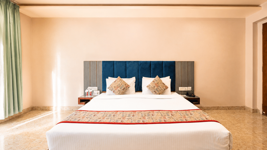 Spacious guest room with king size bed and soft lighting at Bamboo Saa Mulberry Resort, Pushkar.