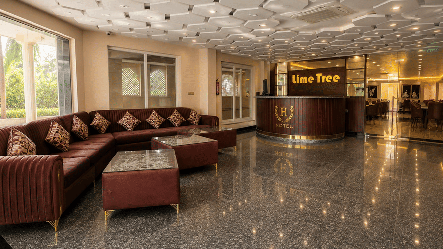 The spacious lobby lounge area at Lime Tree Hotel & Banquet, Jaipur, featuring brown leather sofas, coffee tables, and a polished granite floor.