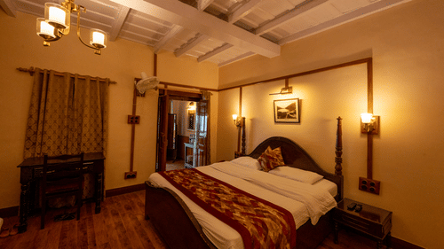 Side view of Heritage Room with a cosy bed and stylish interior lighting at Himalaya Hotel, Nainital