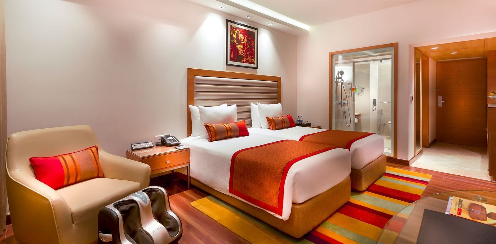 Grand Club Room with twin size beds and sofa chair at Grand Chennai By GRT Hotels.