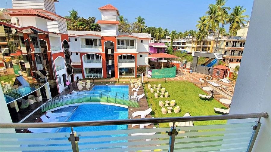 a balcony view of the swimming pool and grass area from one of the rooms - VITS shanti solitaire, North Goa