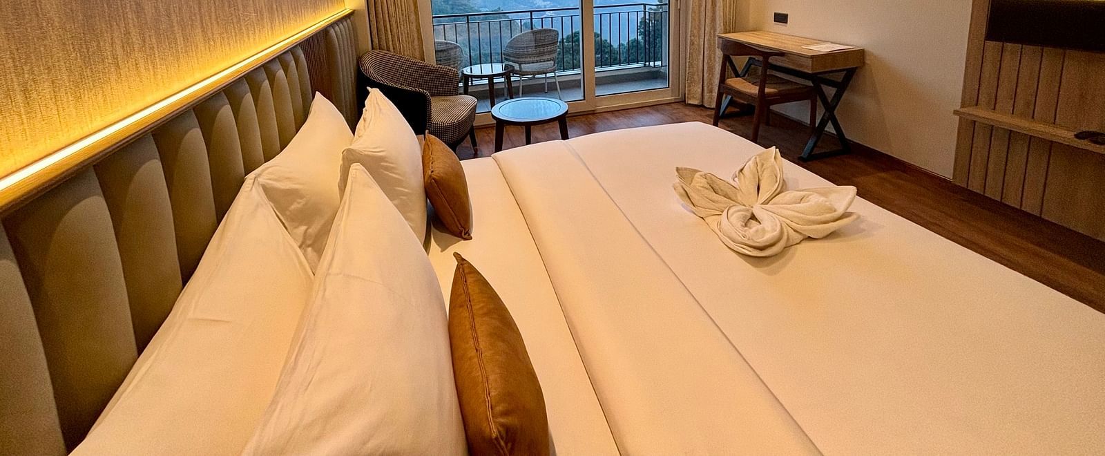 Elegant bedroom with a double bed, ambient lighting, and a large window showing a mountain view –ARNISA Boutique Hotel
