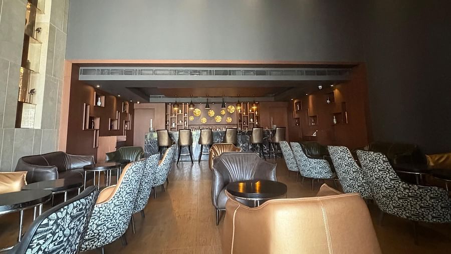 A dimly lit bar with patterned seating, focusing on the bar's seating arrangement and overall atmosphere.