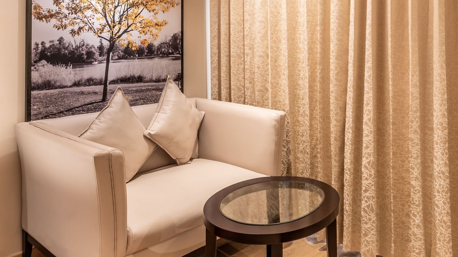Lounge chair beside a window with curtains and framed artwork- TGI Grand Fortuna, Krishnagiri Main Road, Hosur